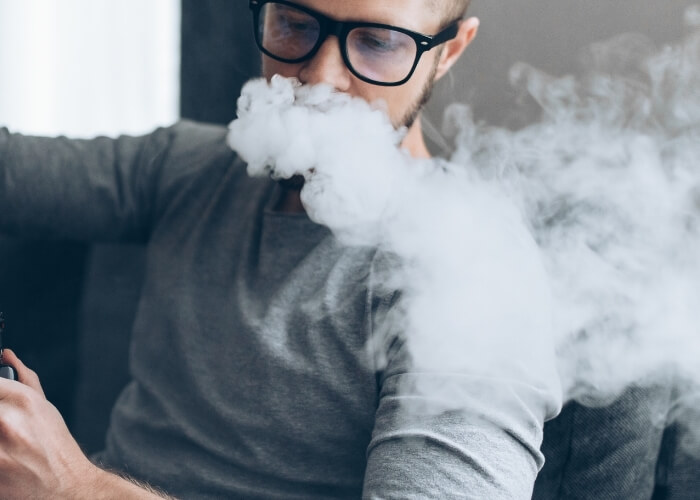 man vaping on couch